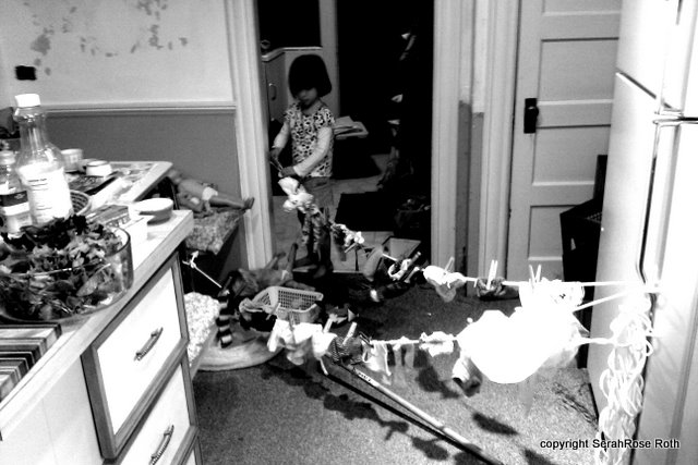 IMAG0020 child hanging doll laundry in kitchen